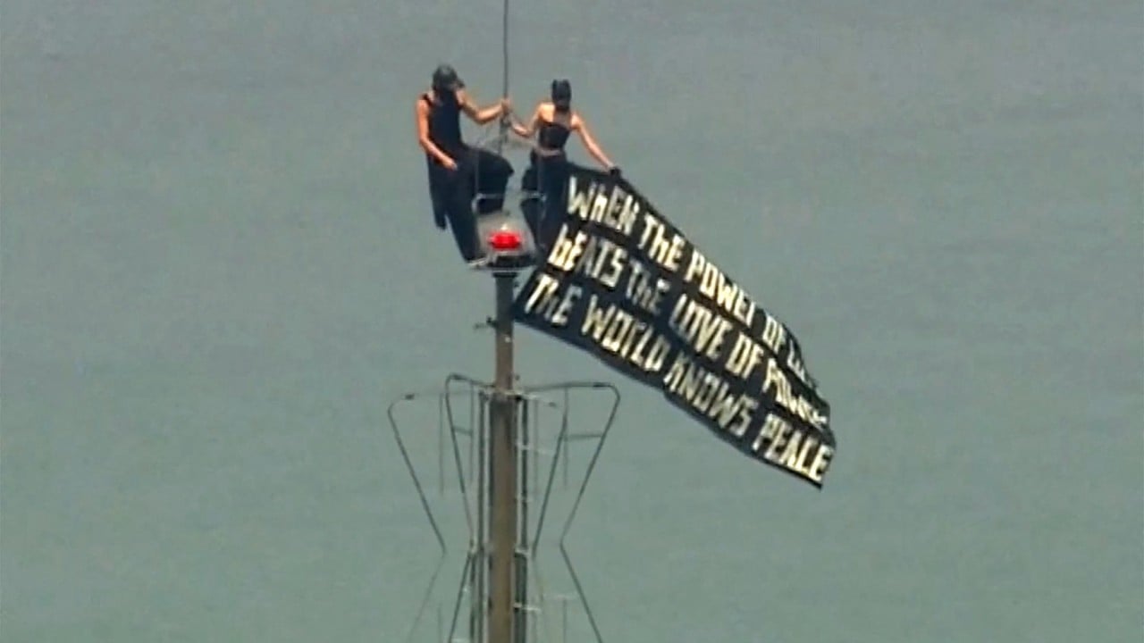 Dua orang menggantung spanduk cinta di puncak Empire State Building.
